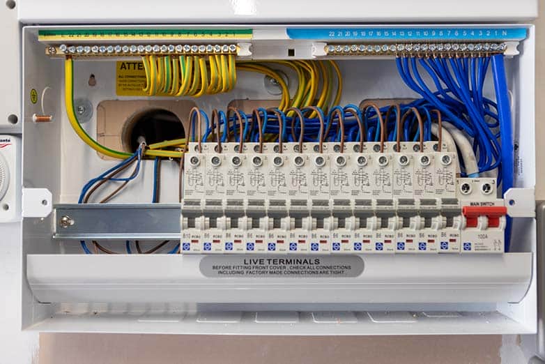 A close-up view of an open modern consumer unit (fuse board) showing extremely tidy internal wiring, RCBO circuit breakers, and busbar connections, demonstrating professional electrical installation standards.